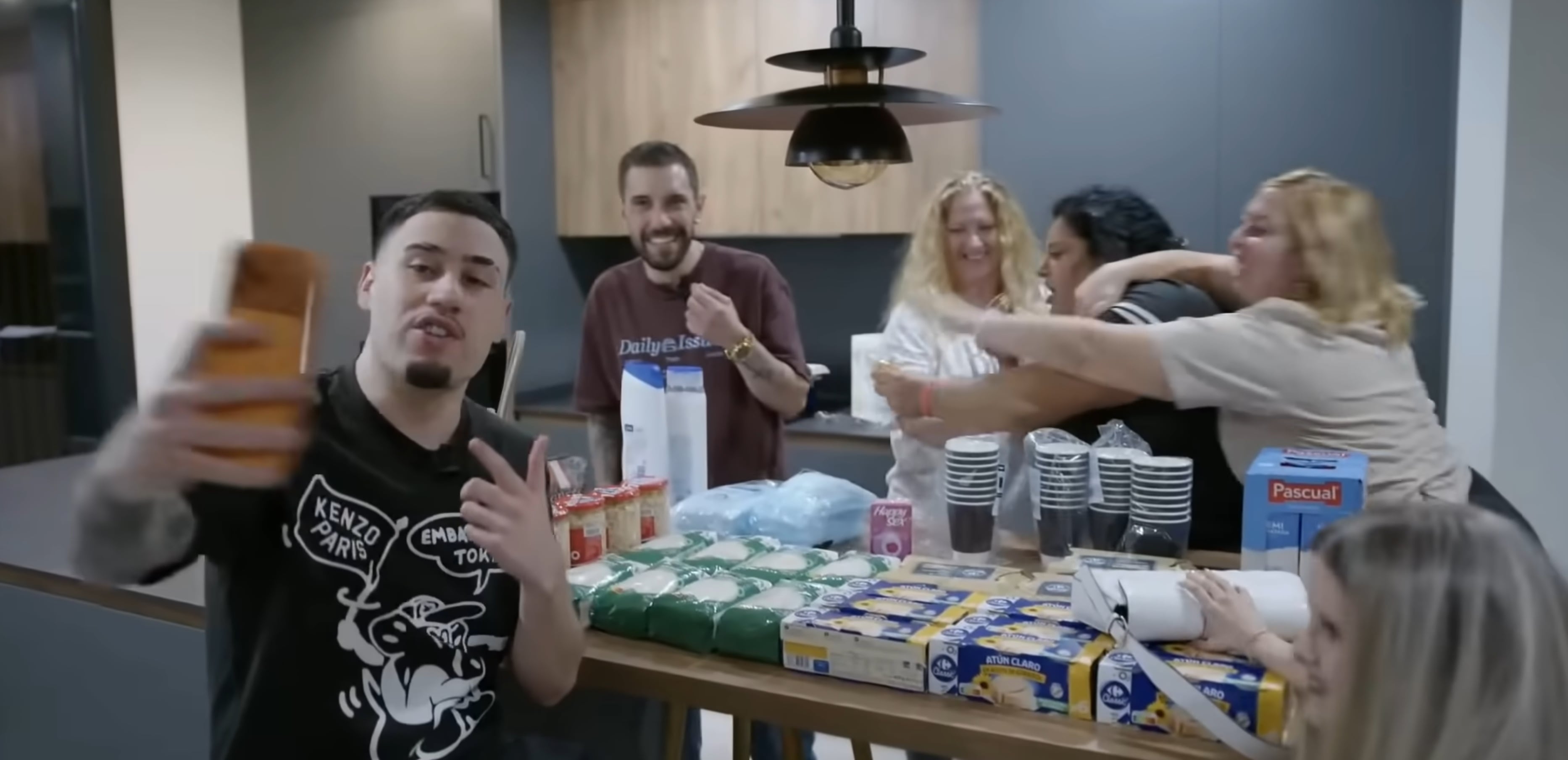 Un fotograma de "La casa de los gemelos" con algunos de los concursantes al fondo junto a uno de los promotores