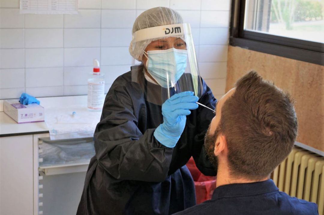 Una sanitaria efectua una prueba PCR a un paciente