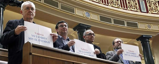 El coordinador general de Izquierda Unida, Cayo Lara, sostiene en el pleno del Congreso celebrado hoy junto a otros diputados de su grupo parlamentario un cartel con el lema &#039;Yo también soy el enemigo&#039; en referencia a las declaraciones de un mando policia