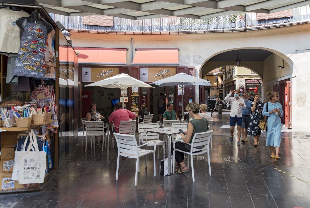 Varias personas pasean por la plaza redonda de València.