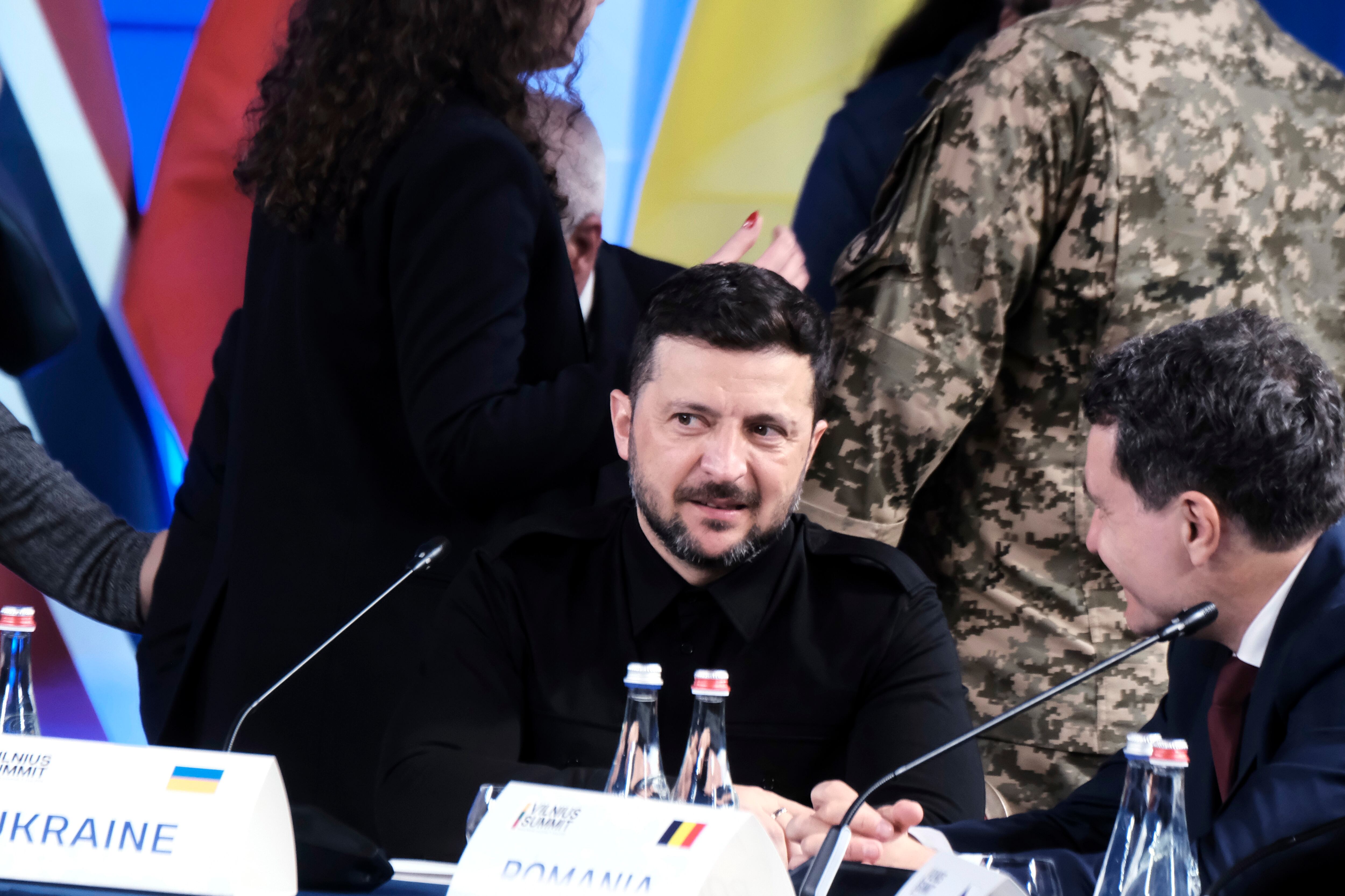 El Presidente de Ucrania, Volodymyr Zelensky (izq.), conversa con el Presidente de Rumanía, Nicusor Dan (dcha.), durante la sesión plenaria de apertura de la Cumbre de Vilna del B9.