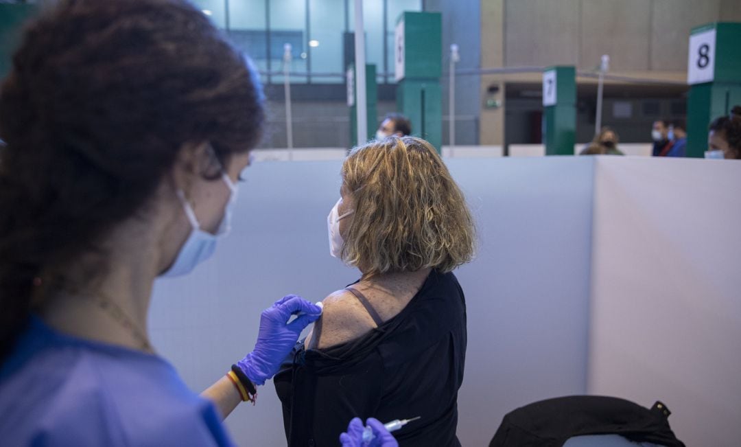 Una sanitaria vacuna a una mujer durante la jornada de vacunación.