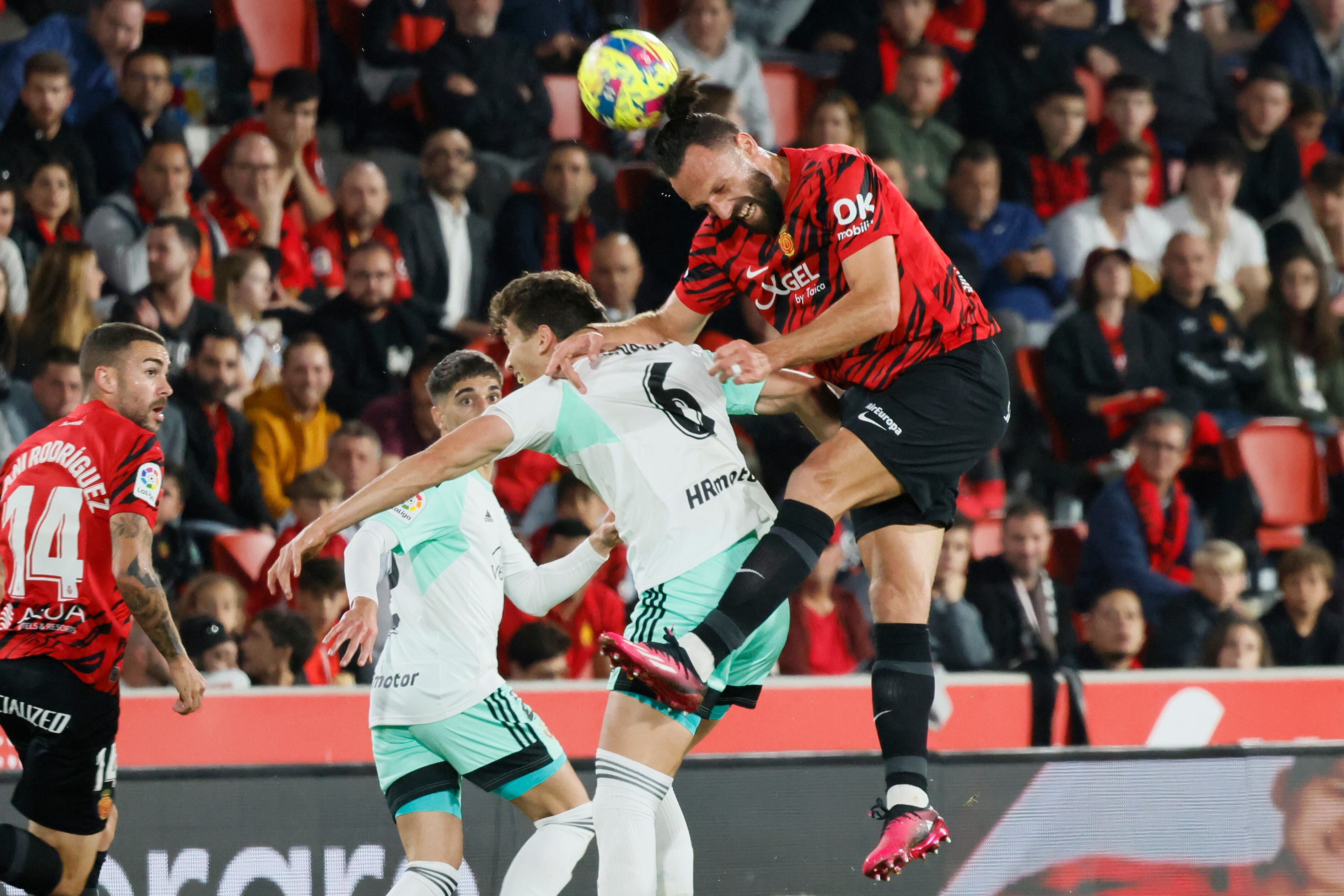 PALMA DE MALLORCA (ISLAS BALEARES), 31/03/2023. El centrocampista de Osasuna, Lucas Torró (2-d), disputa el balón ante el delantero kosovar del Mallorca, Vedat Muriqi (d), durante el encuentro correspondiente a la jornada 27 de primera división disputado hoy viernes en estadio Mallorca Son Moix. EFE/CATI CLADERA.
