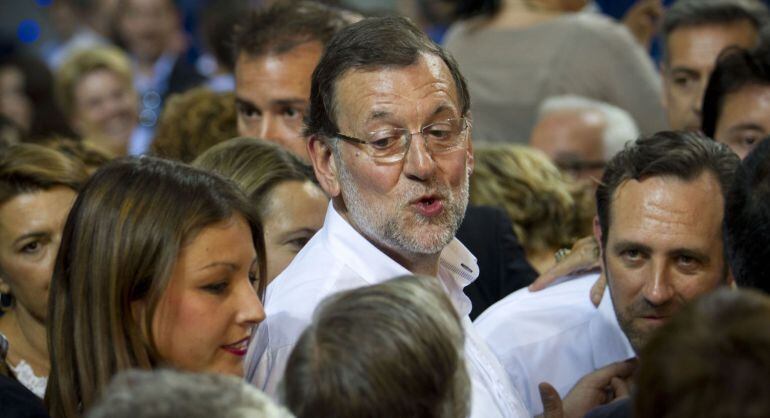 Spanish Prime Minister Mariano Rajoy (C) talks with supporters next to President of the regional government of the Balearic Islands Jose Ramon Bauza (R) at the end of a Popular Party (PP) campaign meeting for the regional and municipal elections in Palma