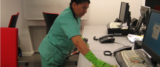 Blanca limpiando uno de los escritorios a las 23 horas. Terminará de trabajar a las 9.30 del día siguiente