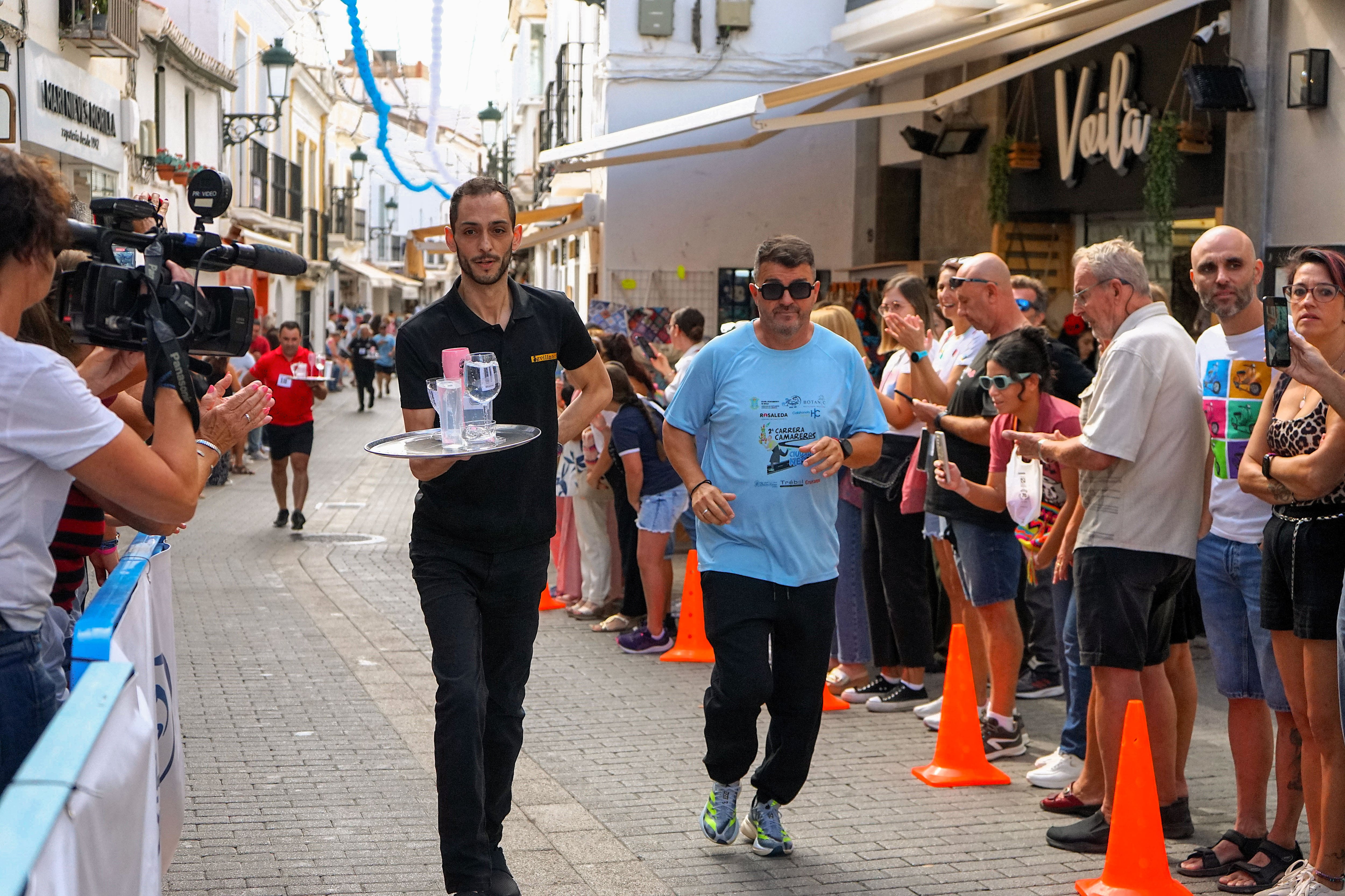 NERJA (MÁLAGA), 09/10/2024.- Decenas de camareros han puesto a prueba sus habilidades con las bandejas este miércoles en Nerja en una carrera urbana por las calles de Nerja donde, sorteando viandantes, han trasportado las bebidas lo más rápido posible intentando llegar a la meta sin derramar el líquido. EFE/María Alonso
