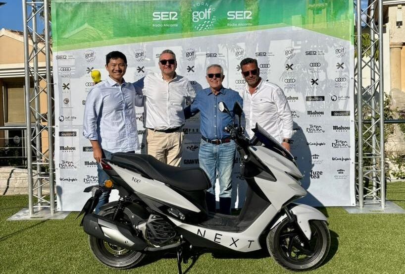 En el centro de la imagen con camisa azul el ganador de la moto de 125 C.C. de Next Motors