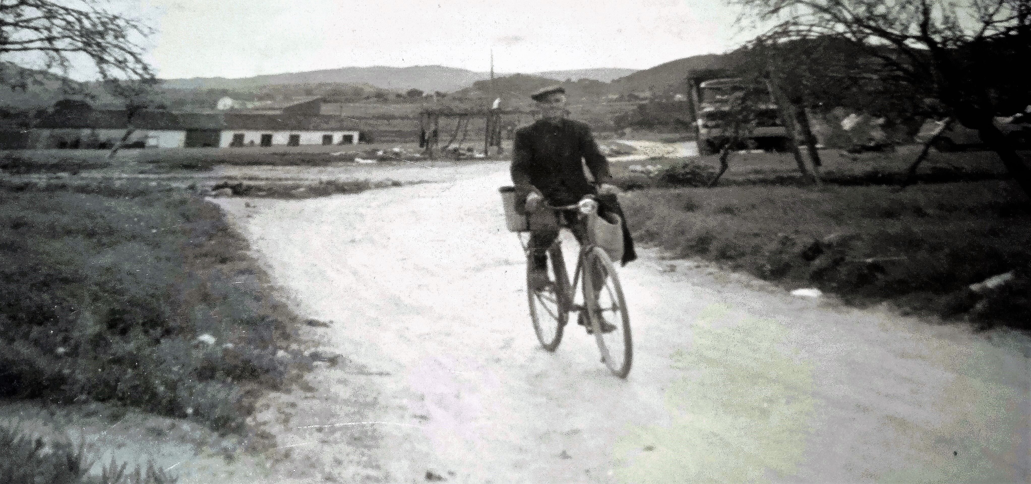 1958. Tomás Vidal Martínez, de oficio panadero. En la fotografía se puede ver al fondo la casa de Los&quot; Chirnaques &quot;, a la orilla de la carretera y a la derecha la casa de Los&quot; Corrines&quot;, tapada por un antiguo camión.  Por allí pasaba Tomás con su bicicleta   regresando del horno a su casa en el Paraje de Los Pachos de Cuesta Blanca, conocida población del Oeste del municipio de Cartagena.