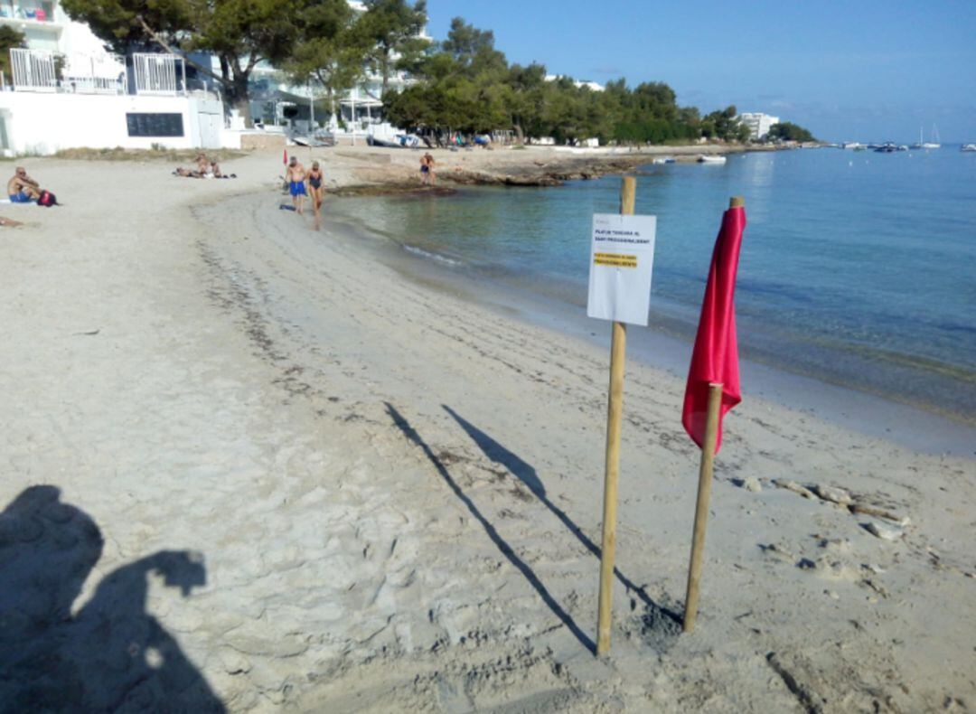 Bandera roja colocada en la playa