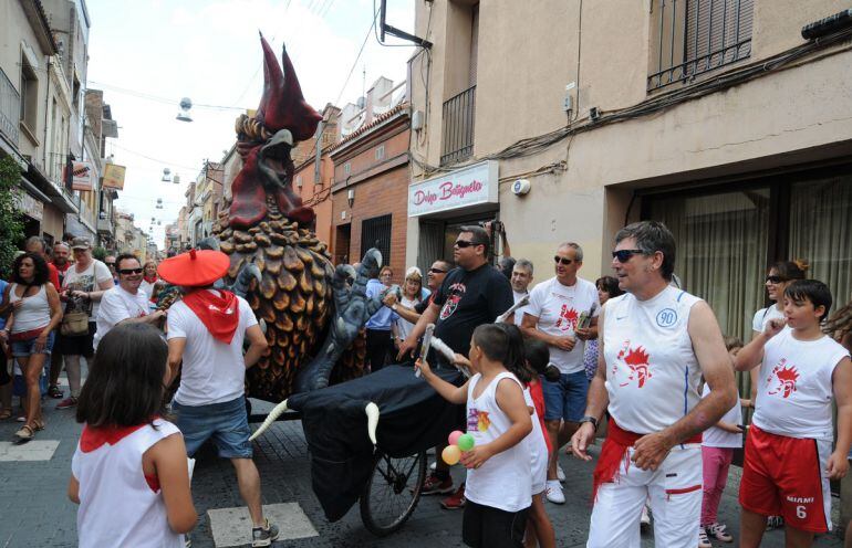 Una imagen de los &quot;encierros de San Pollín&quot; corriendo ante un pollo de mentira por las calles de la localidad 