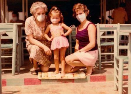 La vicepresidenta Mónica Oltra, de niña, en una foto familiar, con una mascarilla colocada para la campaña Quenadiequedeatrás