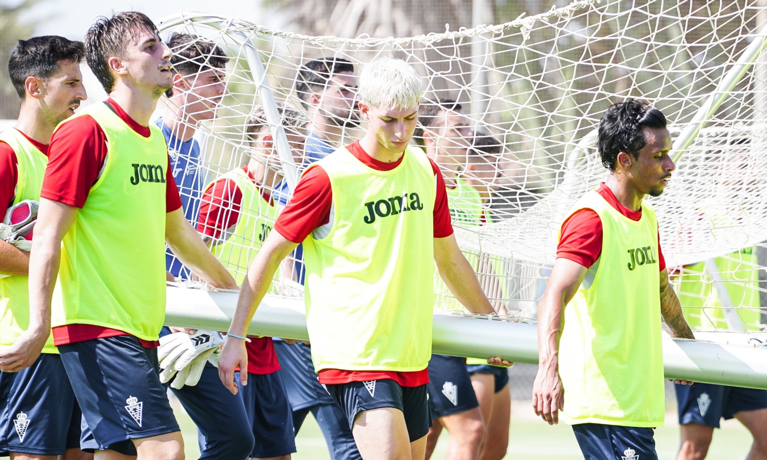Antonio Toral, en el centro, coloca una portería junto a sus compañeros del Real Murcia durante un entrenamiento.