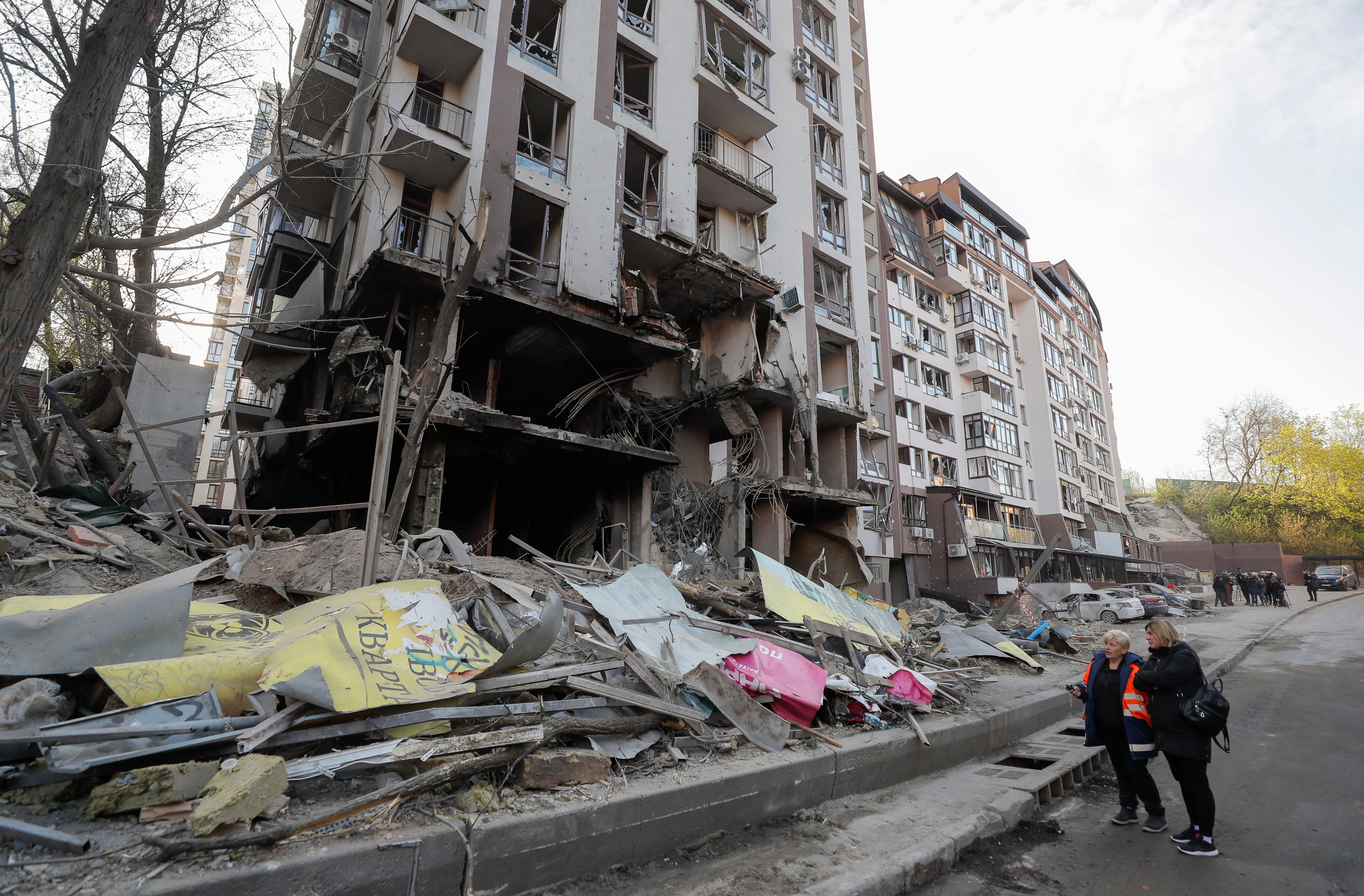 Ciudadanos junto a un edificio destruido en la ciudad de Kiev