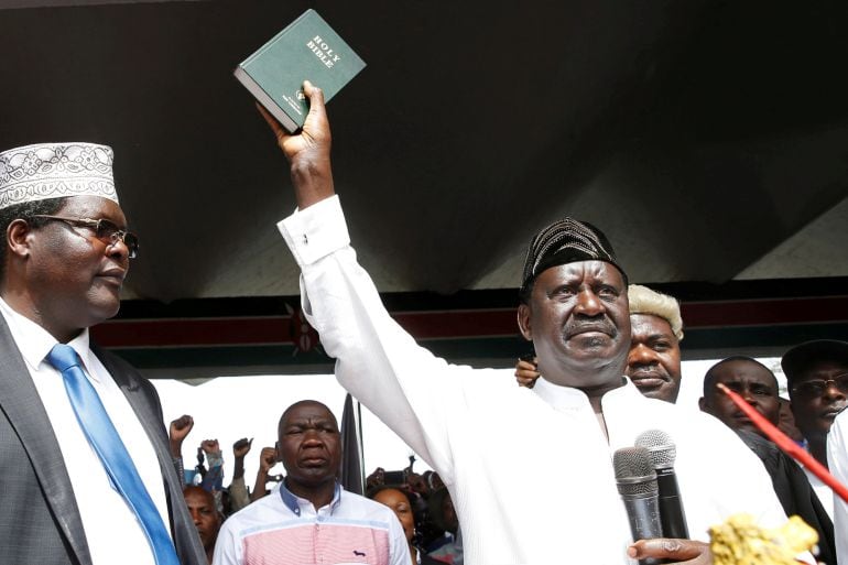  El líder opositor Raila Odinga , de la Alianza Nacional opositora, sujeta una biblia tras tomar un juramento simbolico en la oficina de su partido en Nairobi