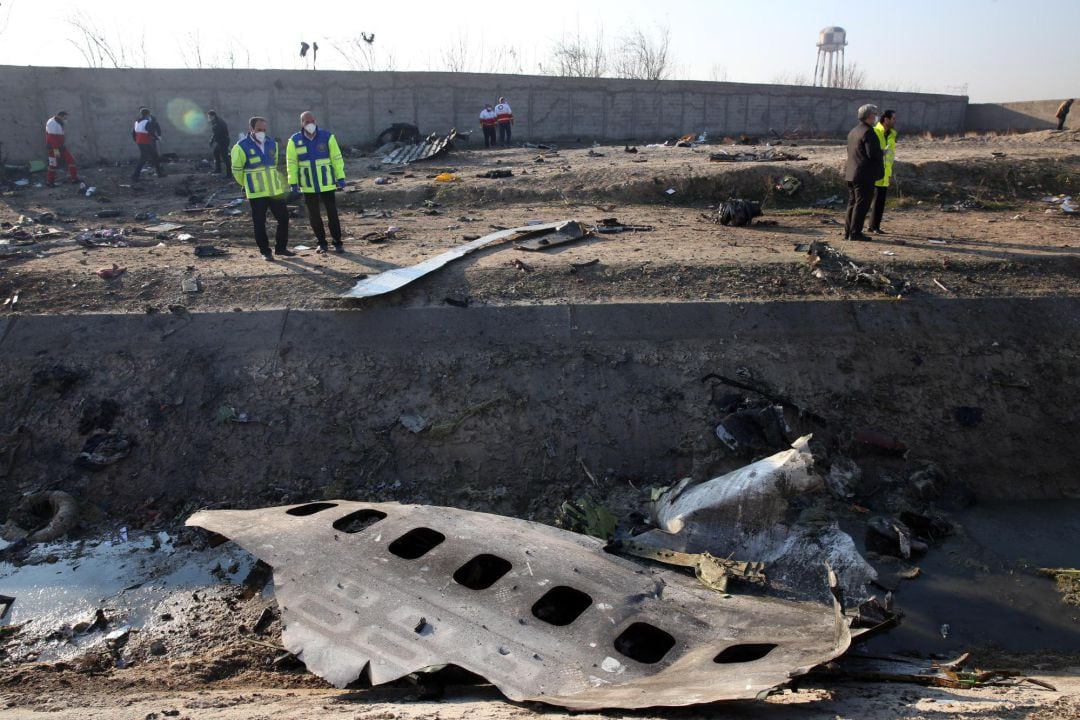 Miembros de los servicios de emergencia observan parte del fuselahe del Boeing 737 de la compañía ucraniana UIA que se ha estrellado esta madrugada en Teherán (Israel). Nacionales de siete países, entre ellos 63 canadienses, han muerto en el accidente aéreo.