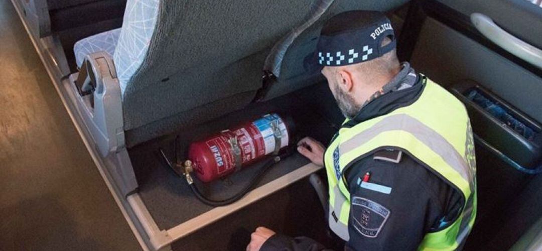 Un agente de Policía inspecciona un autobús