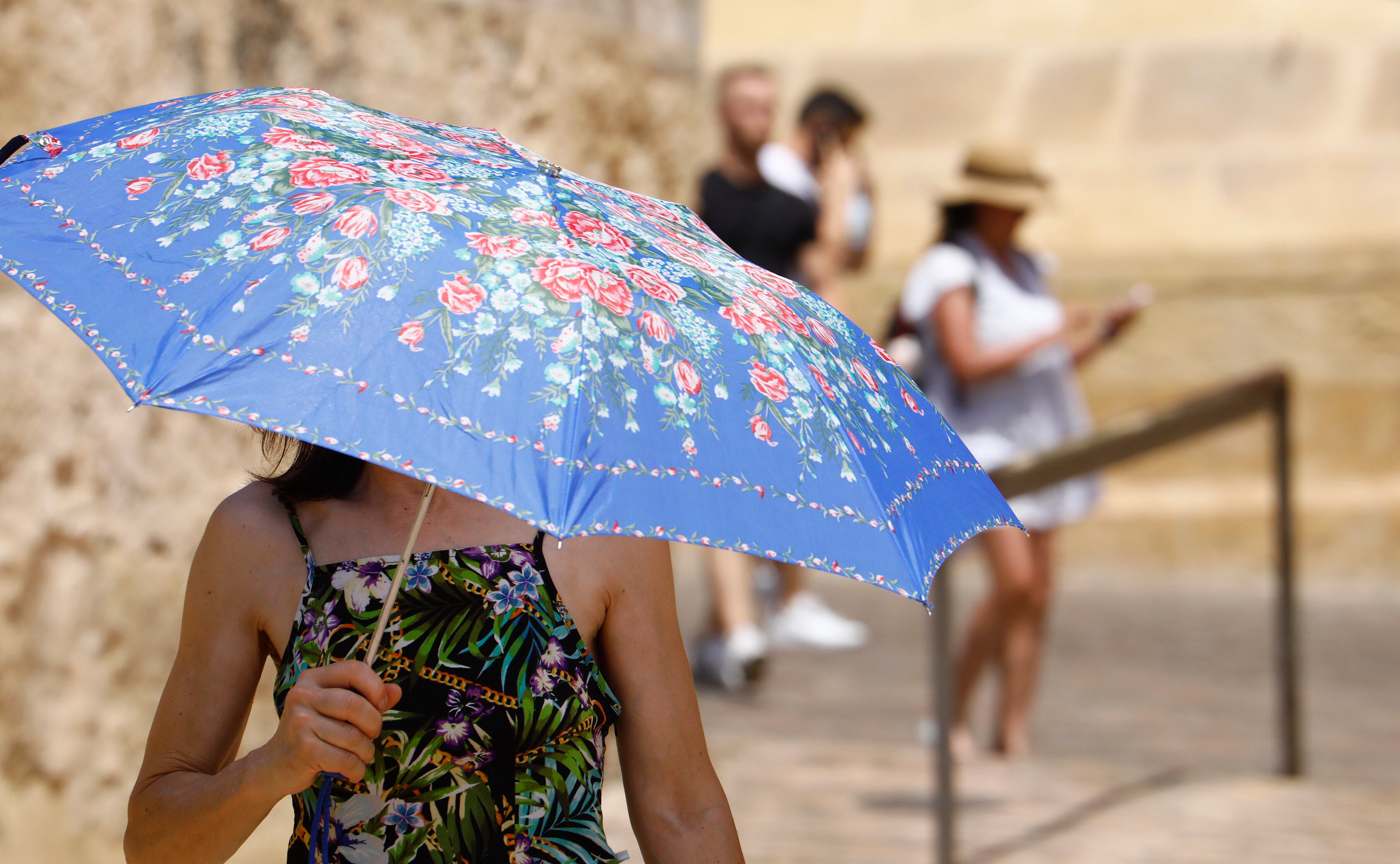 Un turista  se protege del calor con un  paraguas mientras pasea en una jornada de intenso calor donde se esperan llegar a los 37 grados. EFE/Salas