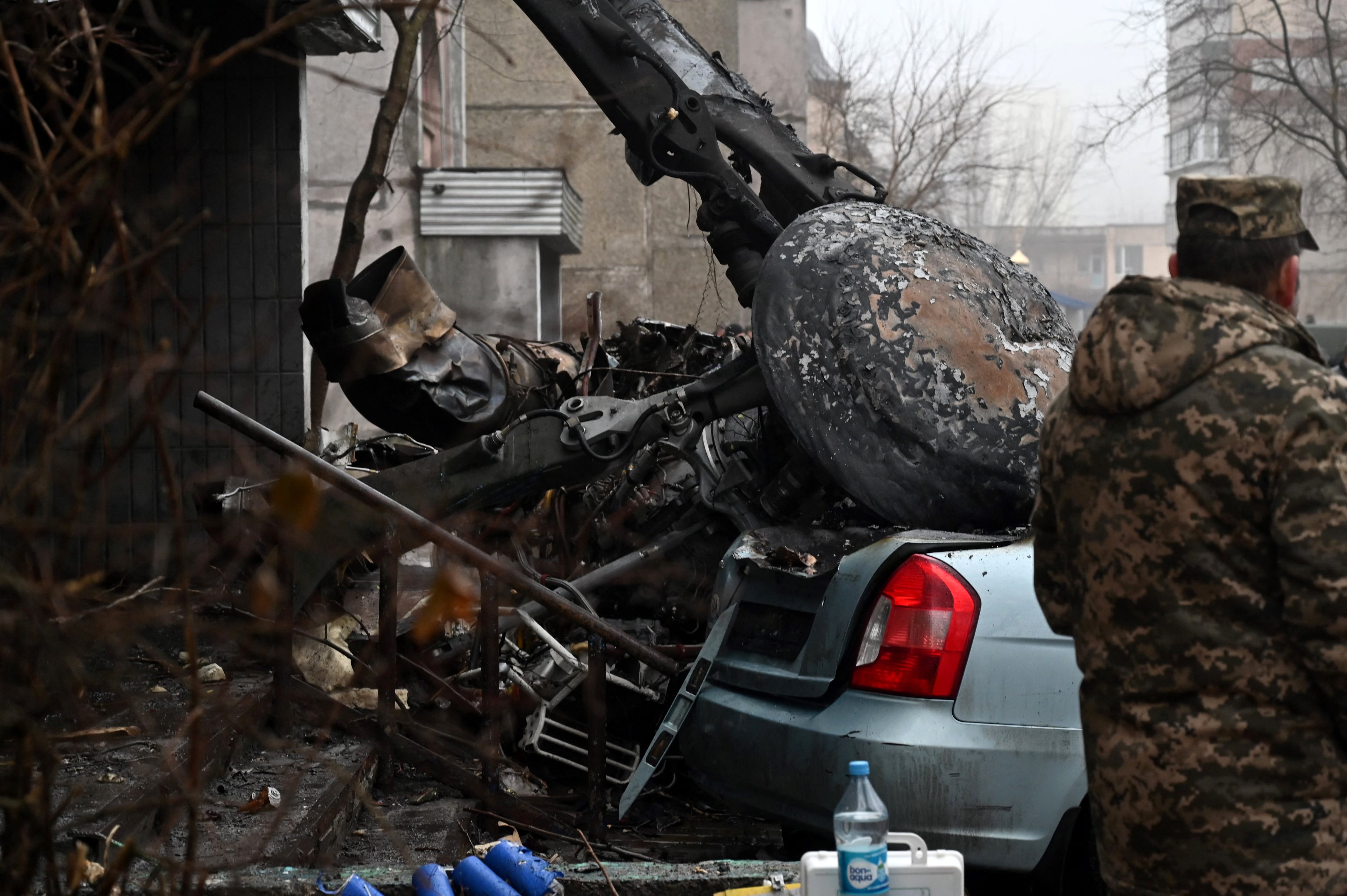 Un militar se encuentra en el lugar donde un helicóptero se estrelló cerca de una guardería en las afueras de Kiev