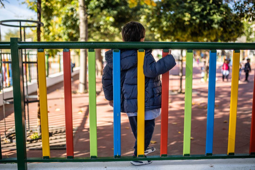 Un niño juega en el patio de un colegio