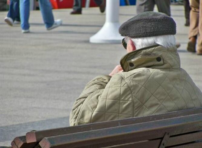 Pensionistas sentado en un banco de una plaza de Canarias