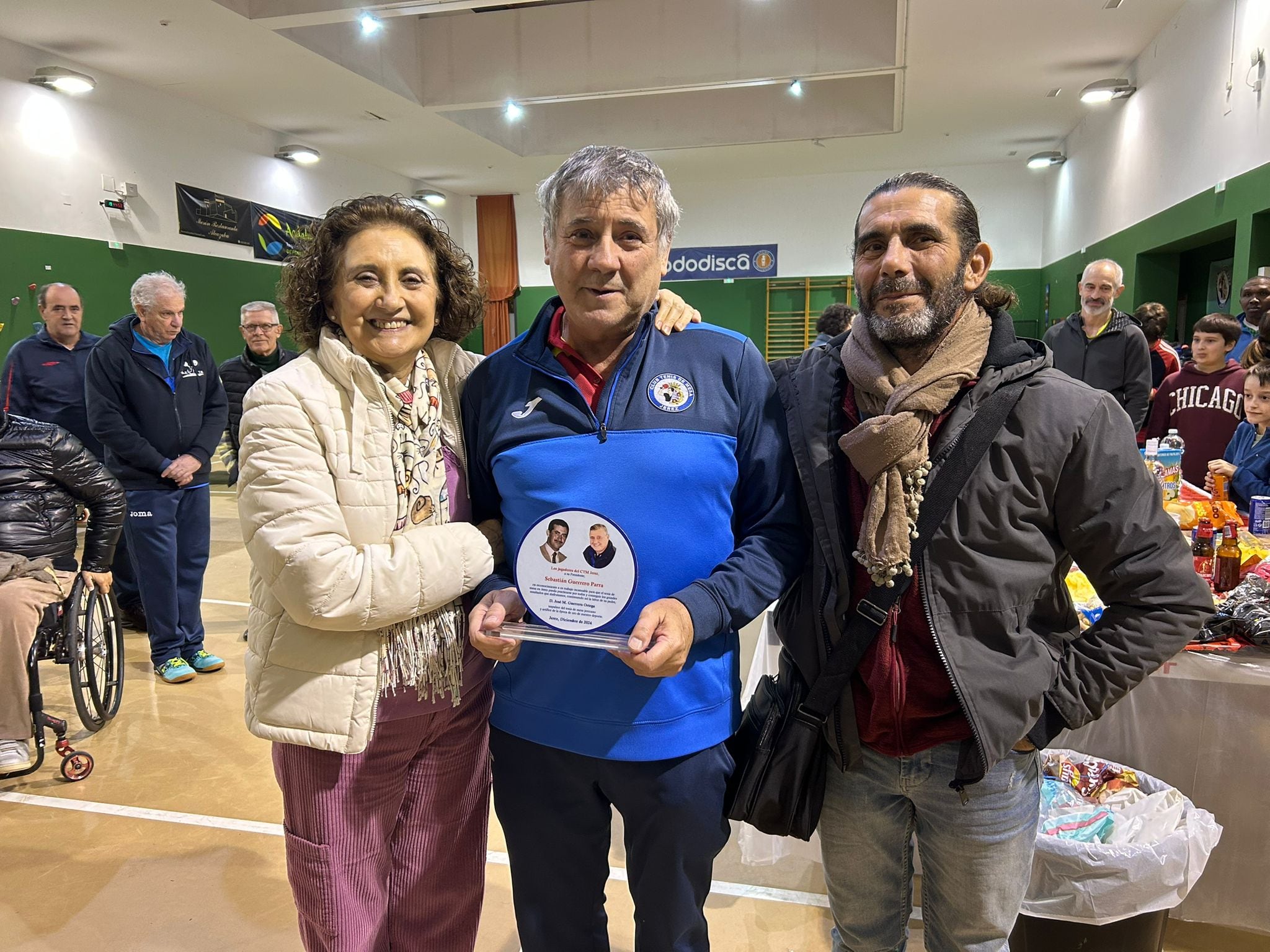 Chano, junto a sus hermanos, Belén y Antonio, con la placa que le entregaron en el homenaje