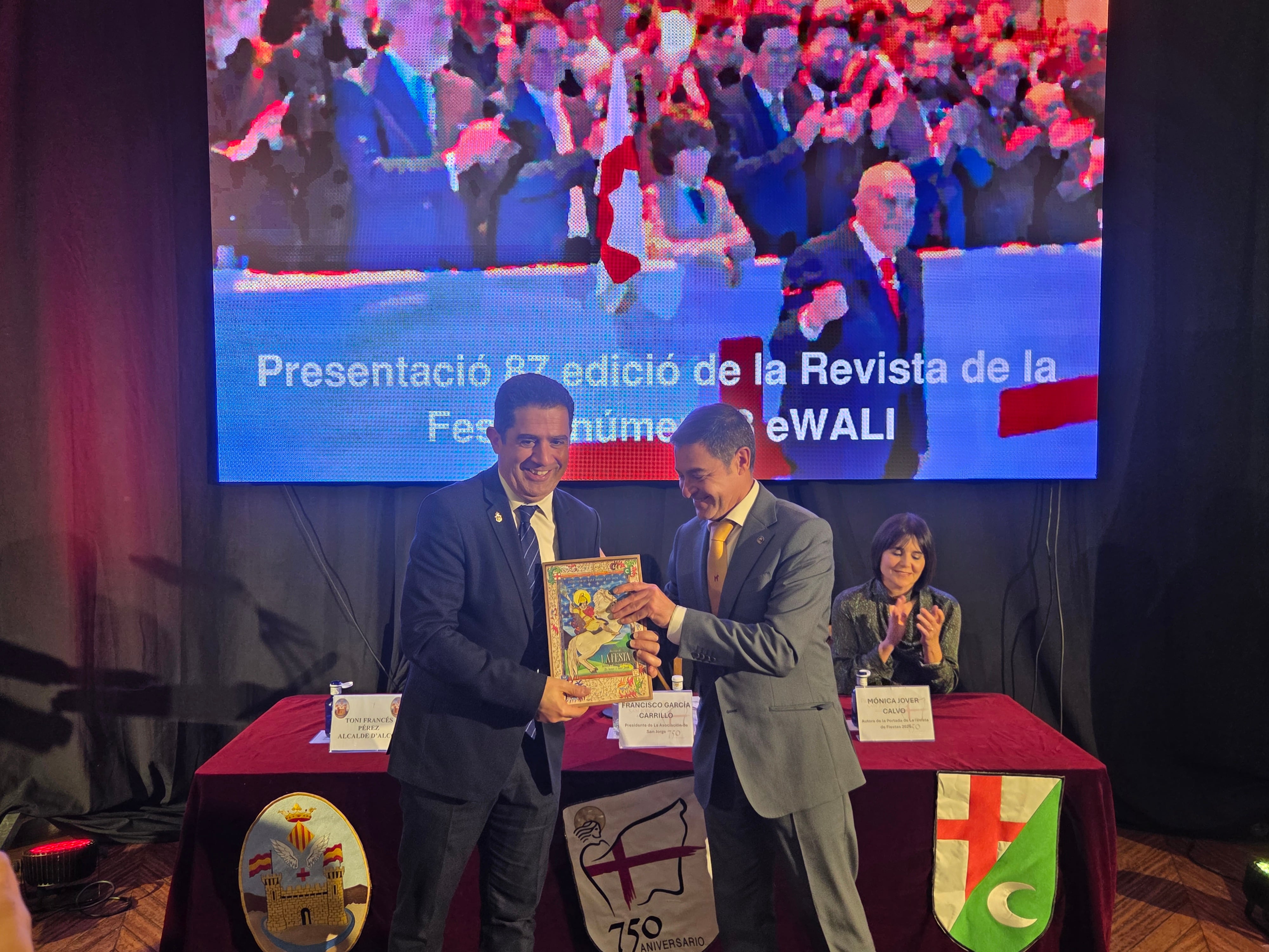 Instante en el que el presidente de la Asociación de San Jorge, Paco García, le entrega al alcalde, Toni Francés, el primer ejemplar de la revista de Fiestas