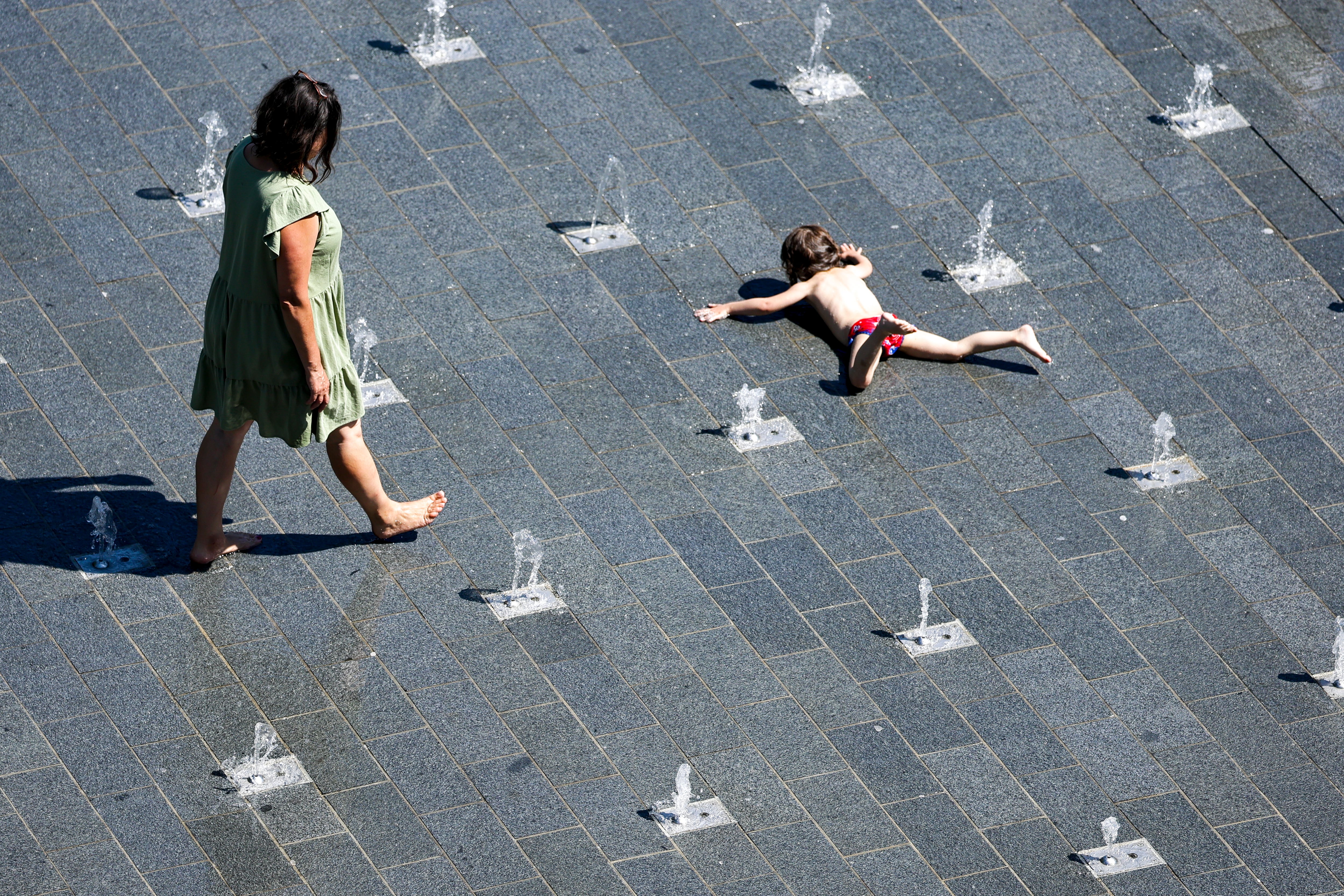 Una mujer y un niño se refrescan ante la ola de calor en Duisburgo (Alemania)