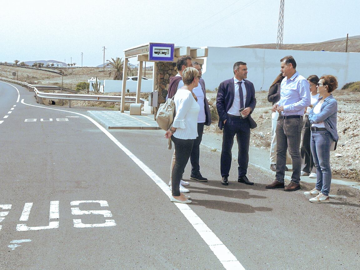 Autoridades insulares y municipales de Haría junto a una marquesina de guaguas.