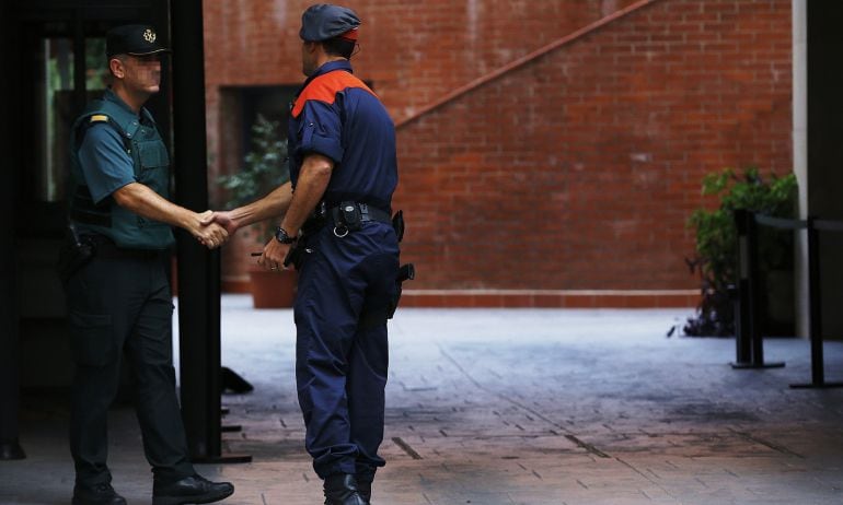 Un mosso d&#039;esquadra saluda a un guardia civil en la entrada de la caserna de Travessera de Gracia, en Barcelona, donde permanecían los detenidos de la operación Anubis.