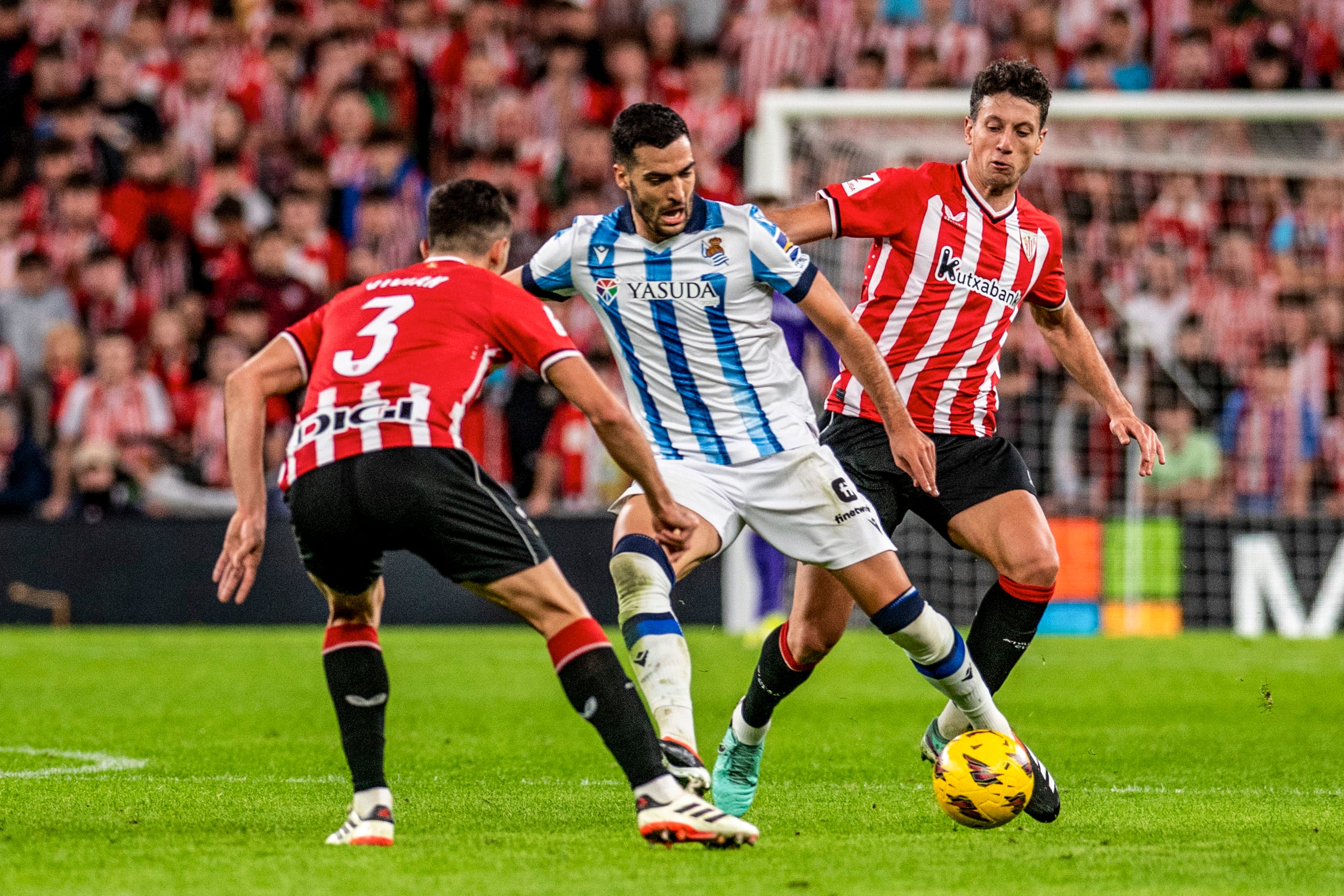 BILBAO, 13/01/2024.- El centrocampista de la Real Sociedad Mikel Merino (c) juega un balón entre Mikel Vesga (d y Daniel Vivian, ambos del Athletic, durante el partido de la vigésima jornada de LaLiga que Athletic Club de Bilbao y Real Sociedad disputan este sábado en el estadio de San Mamés. EFE/Javier Zorrilla
