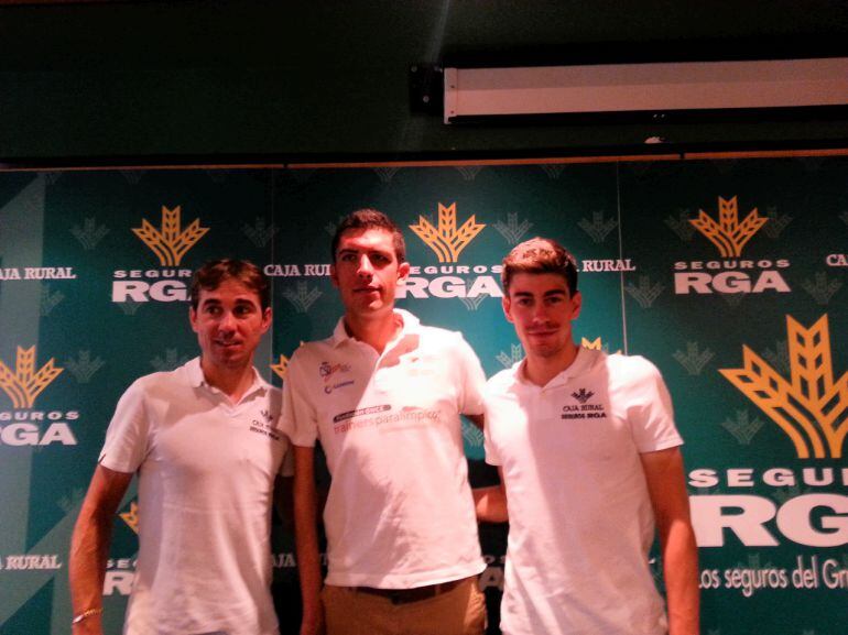 El líder del Caja Rural Seguros RGA, David Arroyo, y su compañero, Jaime Rosón, flanquean al medallista paralímpico, Alejandro Sánchez, durante la presentación.