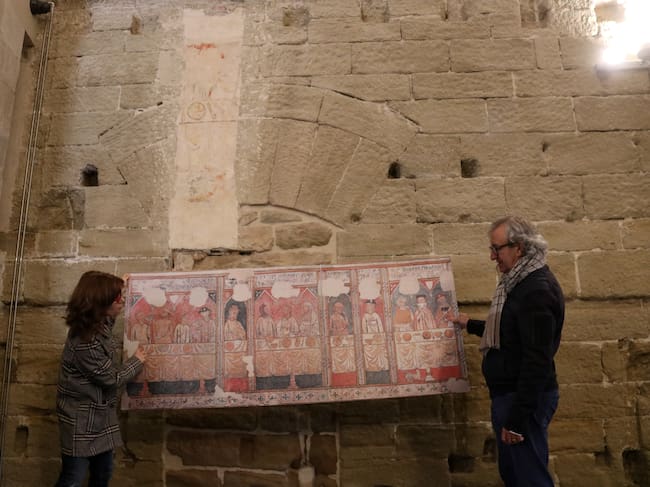 La directora del Museu de Lleida i el director del Consorci del Turó de la Seu Vella ensenyen l'indret de la Seu Vella on s'ubicava la pintura de la Pia Almoina, que ara es pot veure al Museu. Foto: ACN