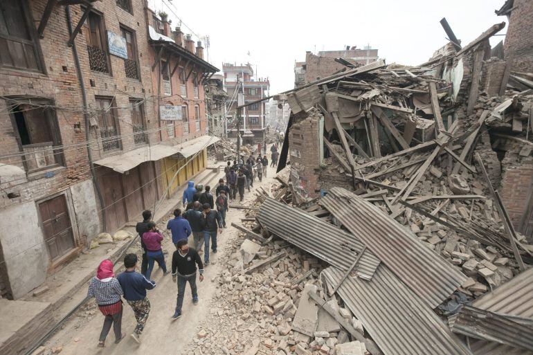 Ciudadanos en busca de un refugio entre edificios totalmente destruidos por el terremot en Katmandú