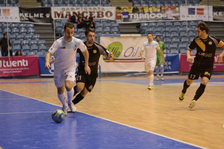 Pablo Tallón conduce el balón por banda superando la presión de dos jugadores del Catgas Santa Coloma