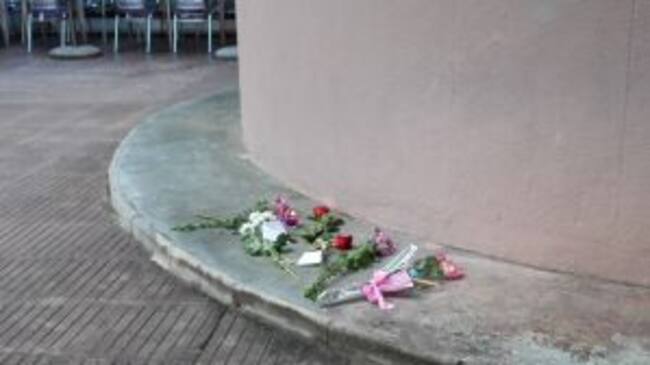 Flors i espelmes al lloc on van morir la mare i les dues filles