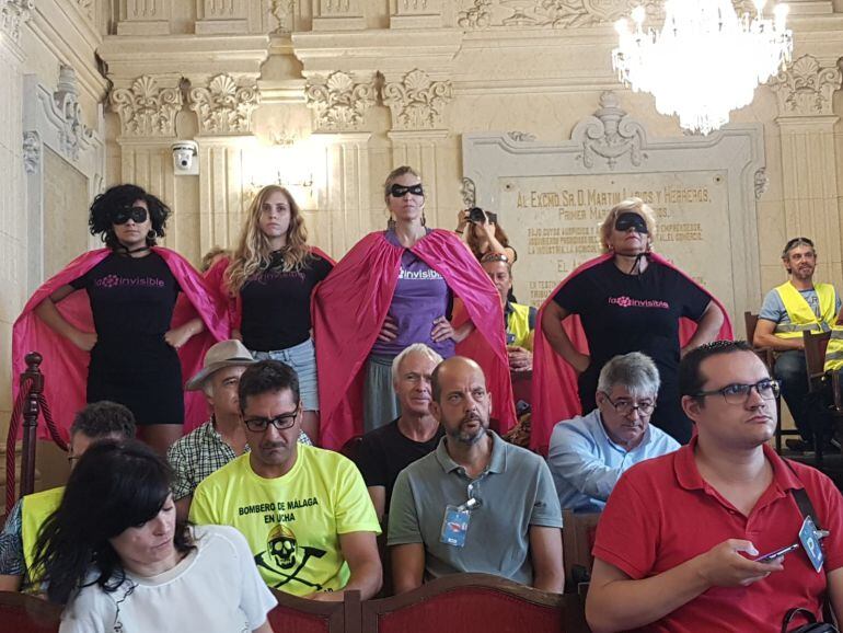 Varias asistentes al pleno municipal del ayuntamiento de Málaga acuden disfrazadas de superheroínas en defensa de La Invisible