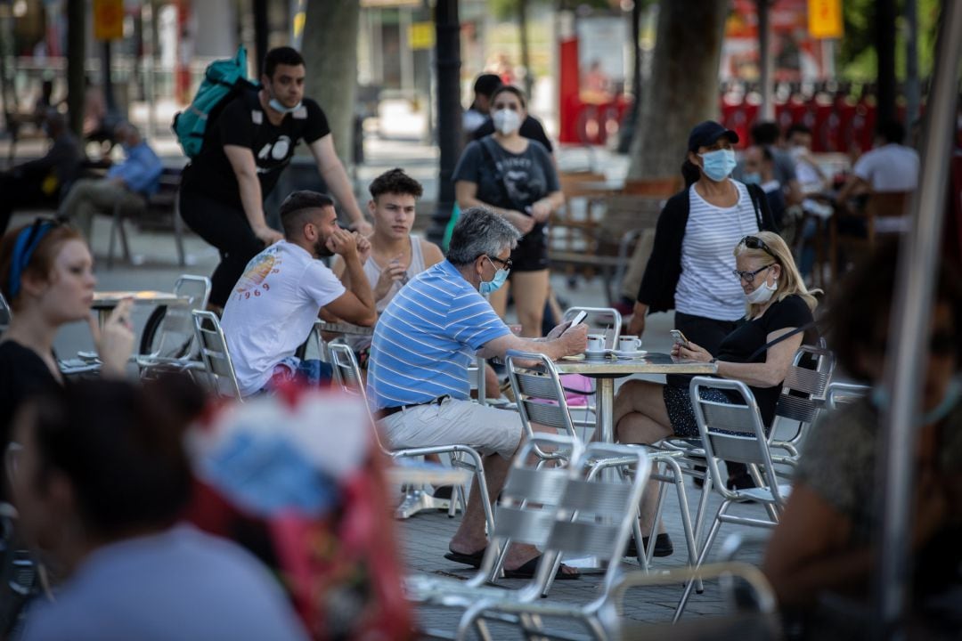 Varias personas disfrutan en la terraza de un bar 
