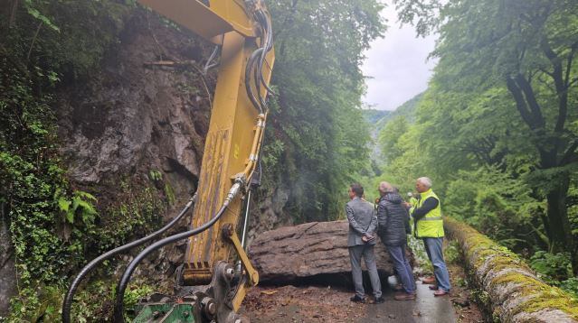 Las autoridades, visitando la carretera con la roca desprendida