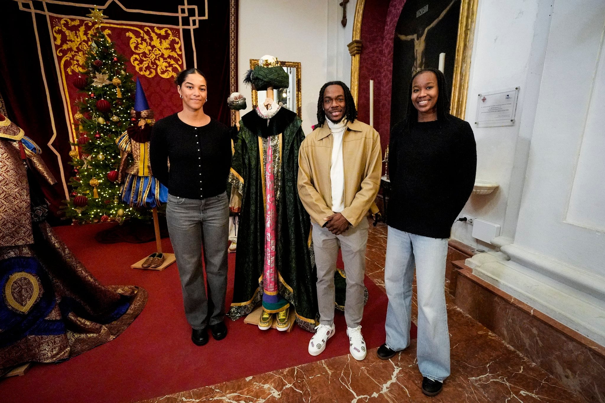 Kendrick Perry posa junto al traje de Baltasar escoltado por las jugadoras del Unicaja femenino Tayra Eke (izquierda) y Bintou Lo Sylla (derecha)