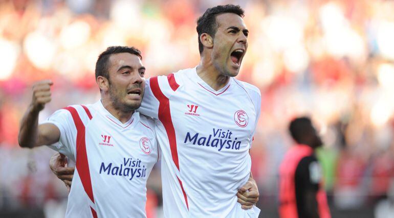 Sevilla's midfielder Vicente Iborra (R) celebrates after scoring a goal with Sevilla's forward Iago Aspas (L) during the Spanish league football match Sevilla FC vs UD Almeria at the Ramon Sanchez Pizjuan stadium in Sevilla on May 17, 2015.   AFP PHOTO / 