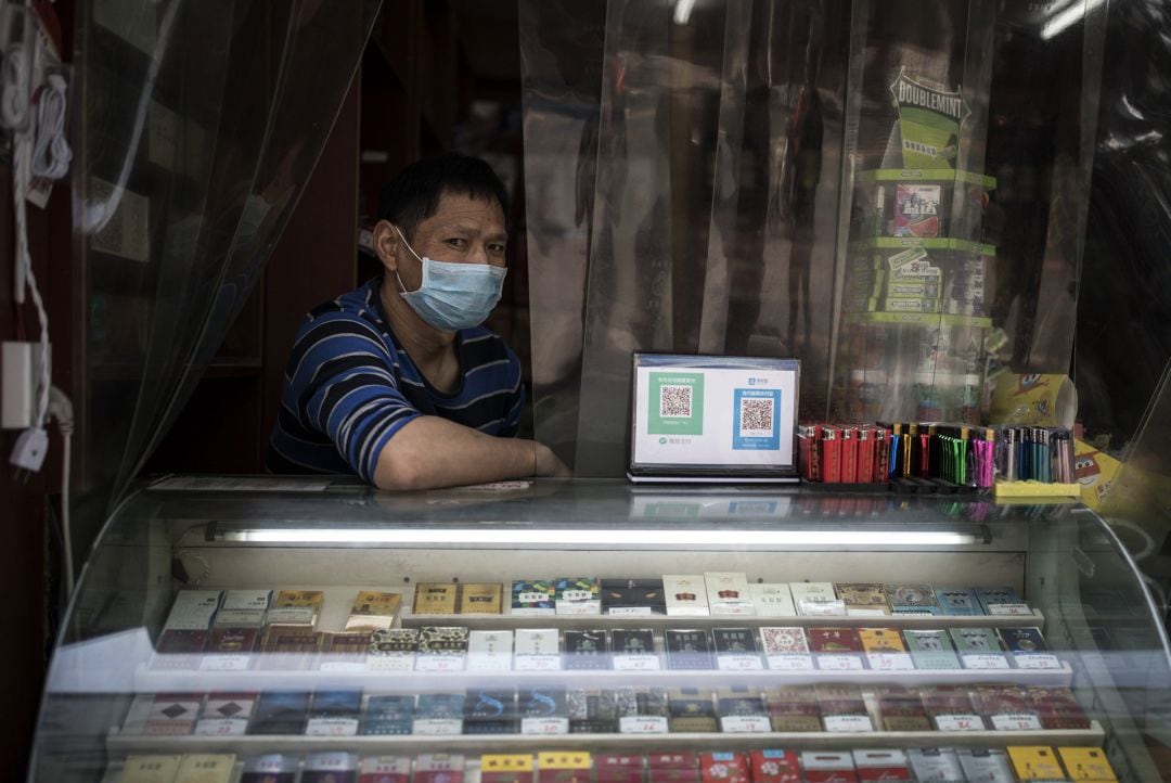 Propietario de un establecimiento con mascarilla en Wuhan.