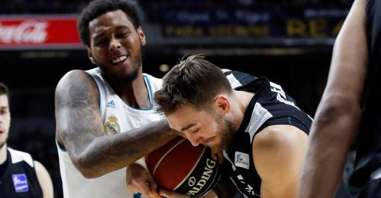 El alero belga del Bilbao Basket Axel Hervelle (d) lucha un balón con el alero estadounidense del Real Madrid Trey Thompkins (i), durante un partido