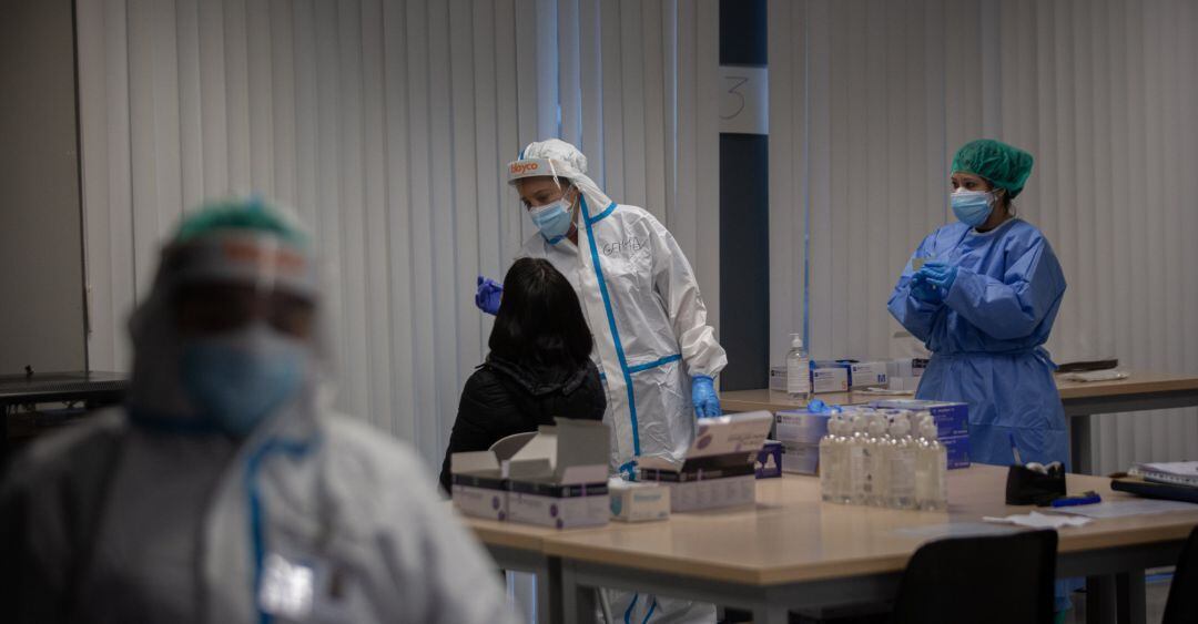 Una mujer recibe una prueba PCR en un dispositivo de cribados masivos.