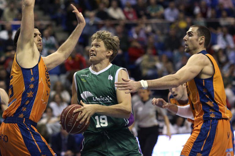 Kuzminskas penetra ante dos jugadores del Valencia