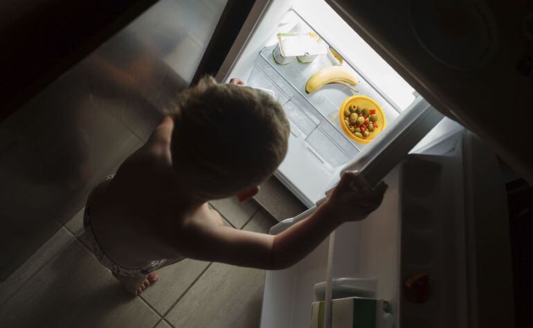 Un niño abre un frigorífico casi vacío / GETTY IMAGES