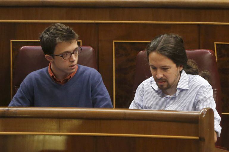 El líder de Podemos, Pablo Iglesias (d) conversa con el portavoz de la formación en el Congreso, Íñigo Errejón, durante el pleno celebrado este miércoles en la Cámara Baja