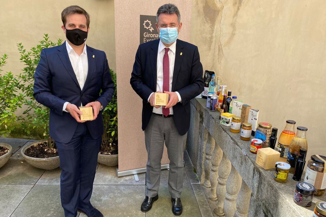 El diputat de Promoció i Desenvolupament Econòmic i Local, Jordi Camps, i el president de la Diputació, Miquel Noguer, amb alguns dels productes