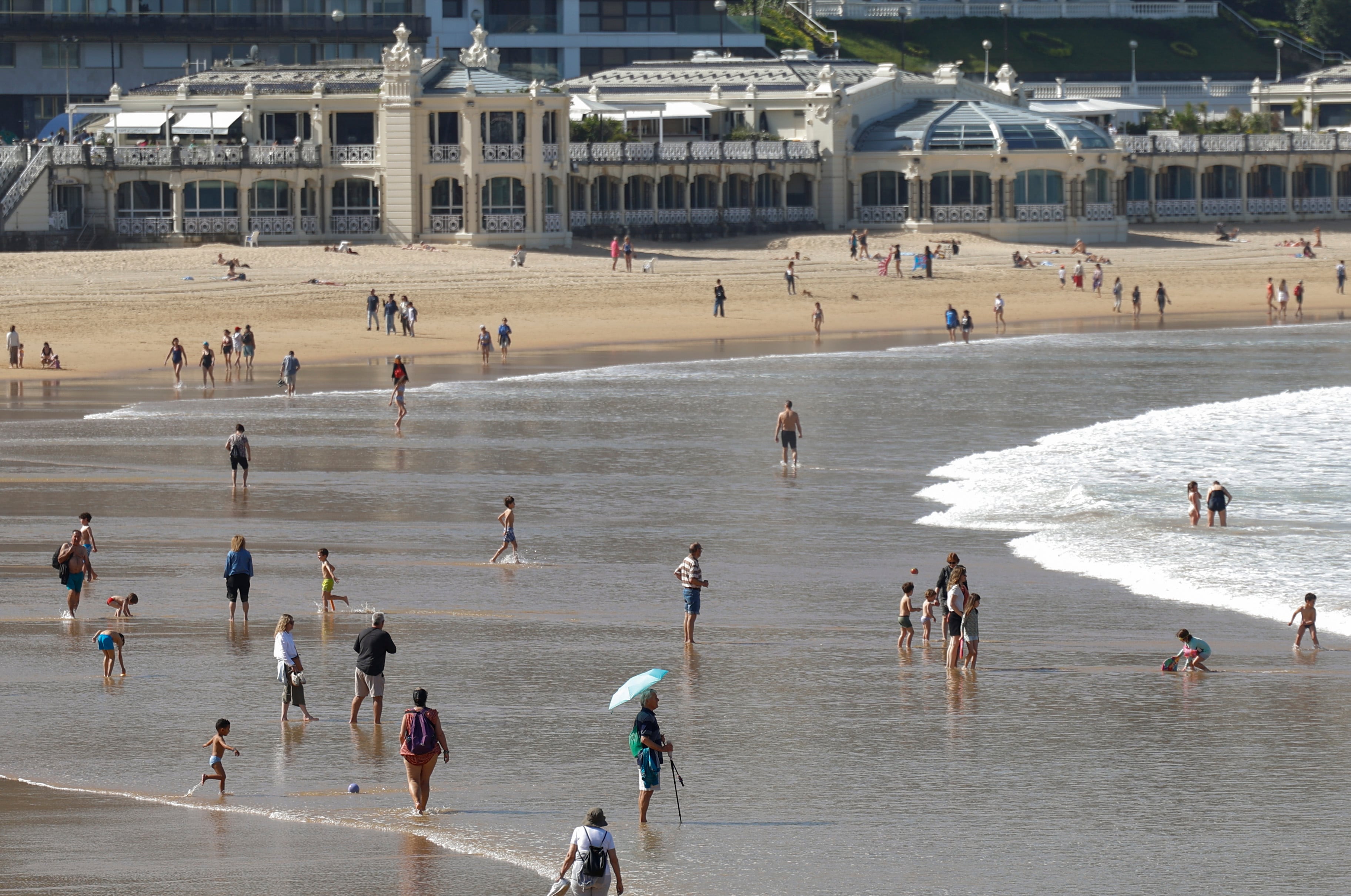 Bañistas disfrutan de un día soleado en la playa de la Concha de San Sebastián.