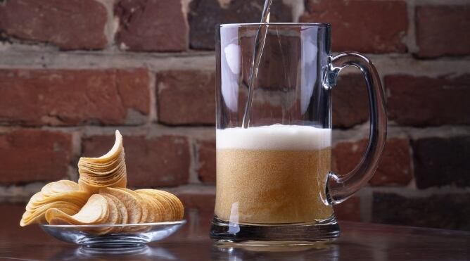 Una jarra de cerveza y un aperitivo de patatas fritas