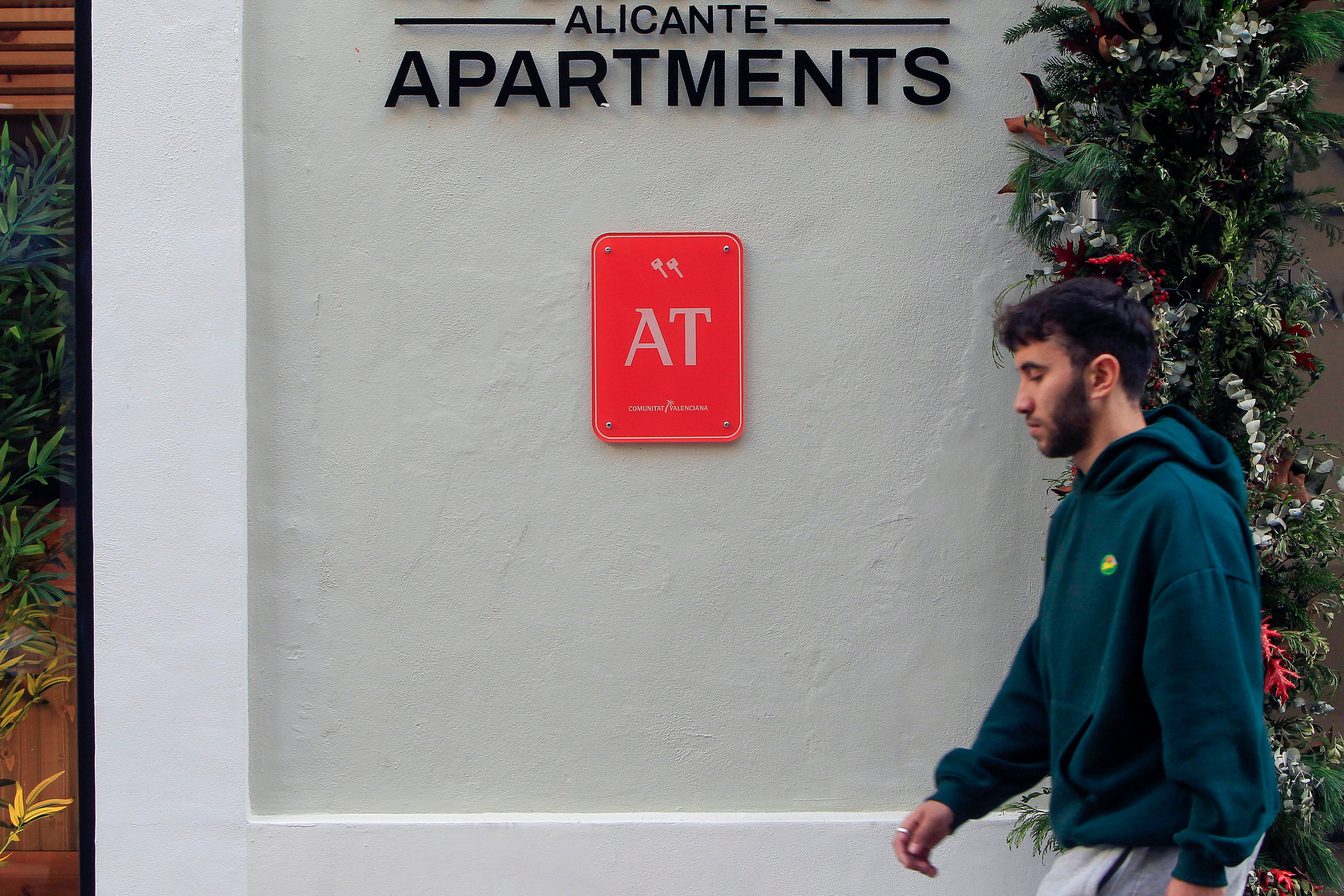 Un joven pasa ante un edificio de apartamentos de Alicante